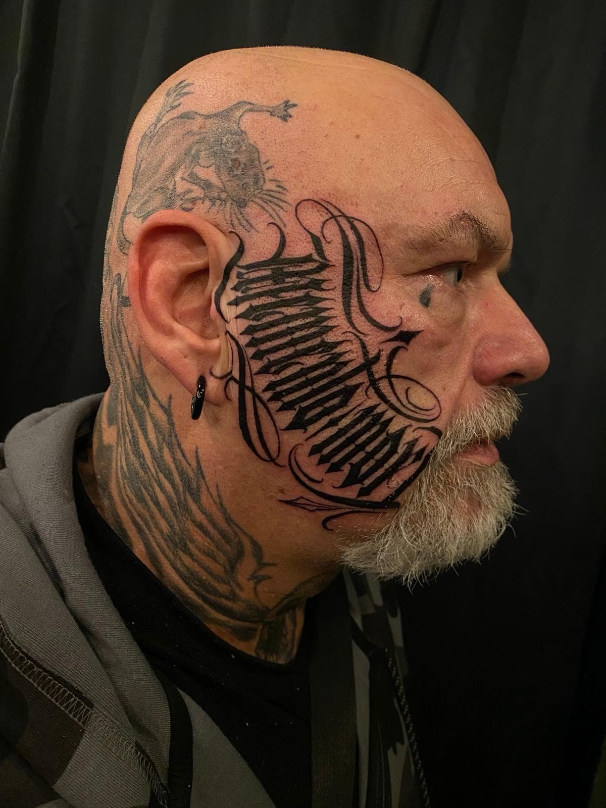 Gothic lettering tattoo in het gezicht — memento mori